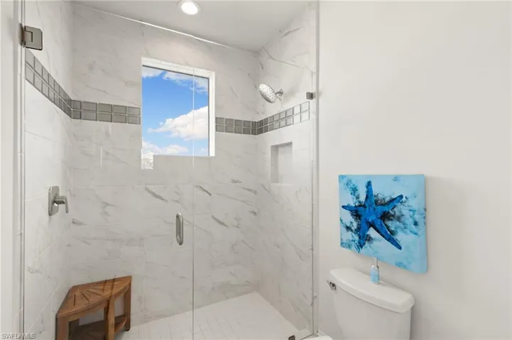 Bathroom with toilet and a marble finish shower