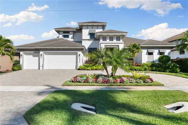 Prairie-style home with stucco siding, a front yard, decorative driveway, a garage, and a tile roof
