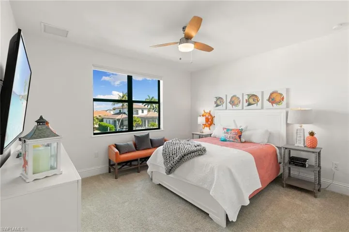 Bedroom with a ceiling fan and light colored carpet