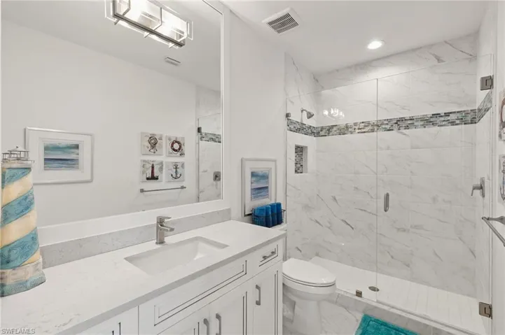 Full bathroom featuring a marble finish shower, vanity, and recessed lighting