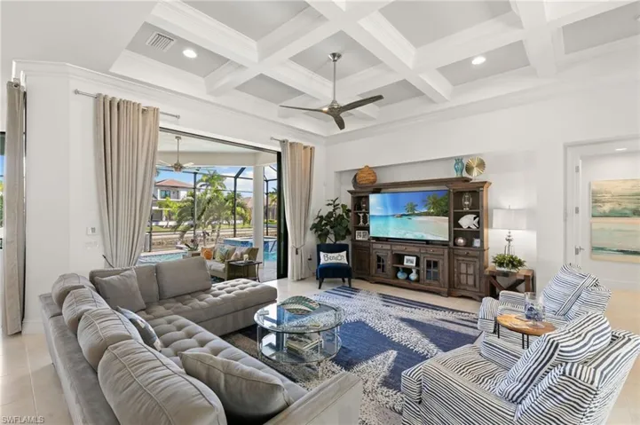 Living area featuring coffered ceiling, a ceiling fan, beam ceiling, recessed lighting, and light tile patterned flooring