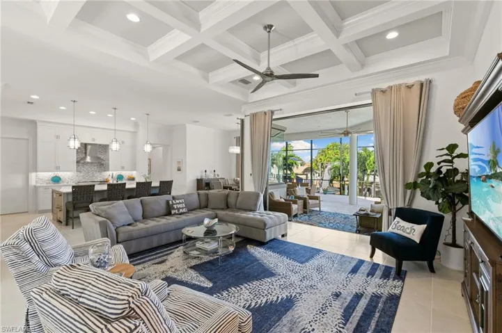 Living room featuring recessed lighting, ceiling fan, coffered ceiling, beam ceiling, and crown molding