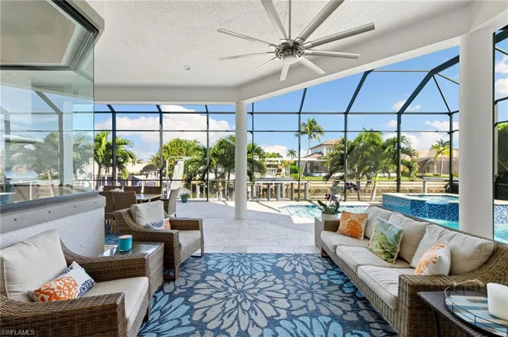 Sunroom / solarium featuring an outdoor living space, a ceiling fan, a patio, and a hot tub