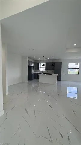 Unfurnished living room featuring marble finish floor and recessed lighting