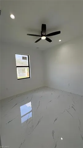 Unfurnished room featuring marble finish floor, baseboards, and recessed lighting