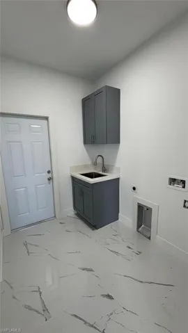Laundry area with washer hookup, marble finish floor, cabinet space, a sink, and electric dryer hookup