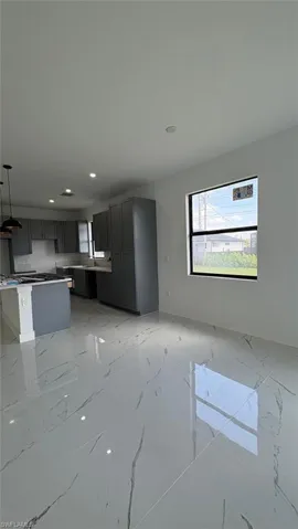Unfurnished living room featuring marble finish floor, a sink, and recessed lighting
