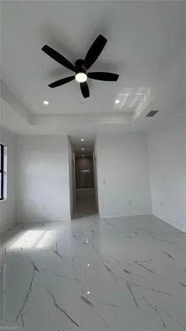 Spare room featuring marble finish floor, visible vents, a raised ceiling, and recessed lighting