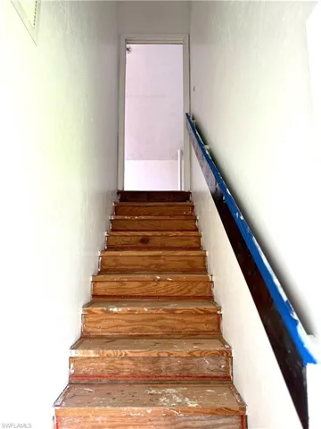 Stairs featuring a textured wall
