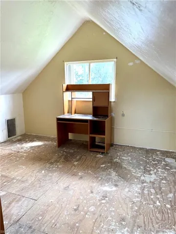 Additional living space with lofted ceiling and a textured ceiling