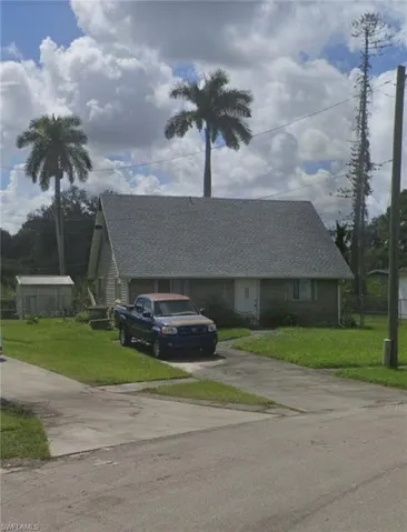 View of front of property with roof with shingles, concrete driveway, and a front lawn
