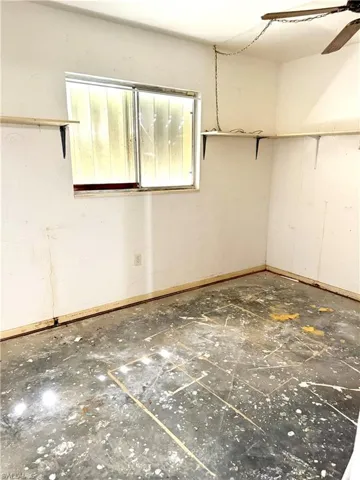 Unfurnished room with baseboards and a ceiling fan