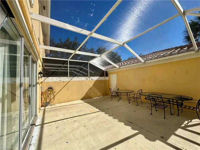 View of patio featuring a lanai, outdoor dining area, and a sunroom