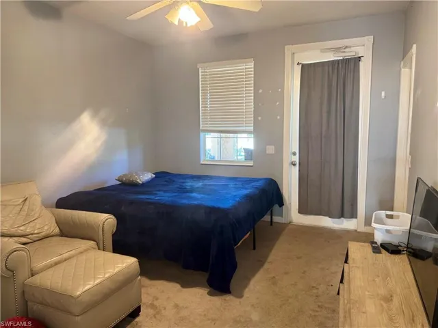 Carpeted bedroom featuring a ceiling fan and baseboards