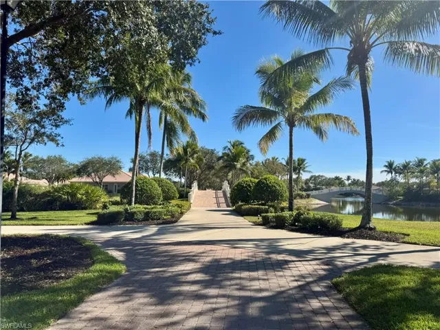View of home's community with a water view and decorative driveway