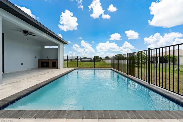 Rectangular pool featuring dark coping and light-toned pavers