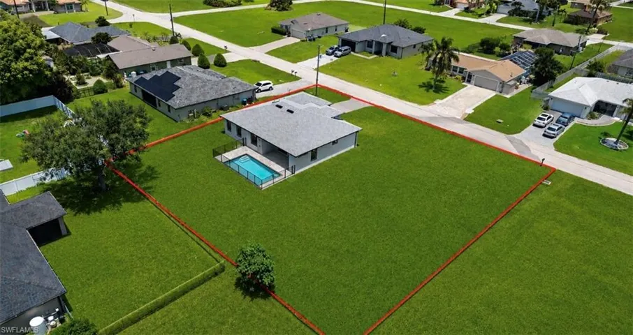 Expansive residential lot featuring a modern single-story home with a gray roof and a private swimming pool