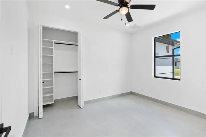 Bright interior room featuring a black ceiling fan, recessed lighting, and a window with black trim