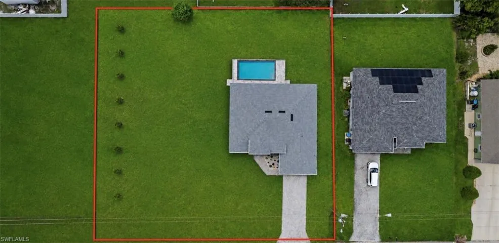 Expansive lot featuring a primary residence with an attached swimming pool