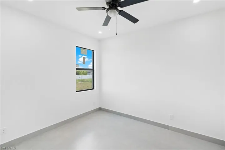 Bright interior featuring a ceiling fan with integrated lighting, recessed ceiling lights, and a single window with black trim