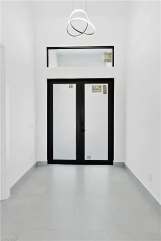 Double entry doors with dark frames and frosted panels, complemented by a transom window above