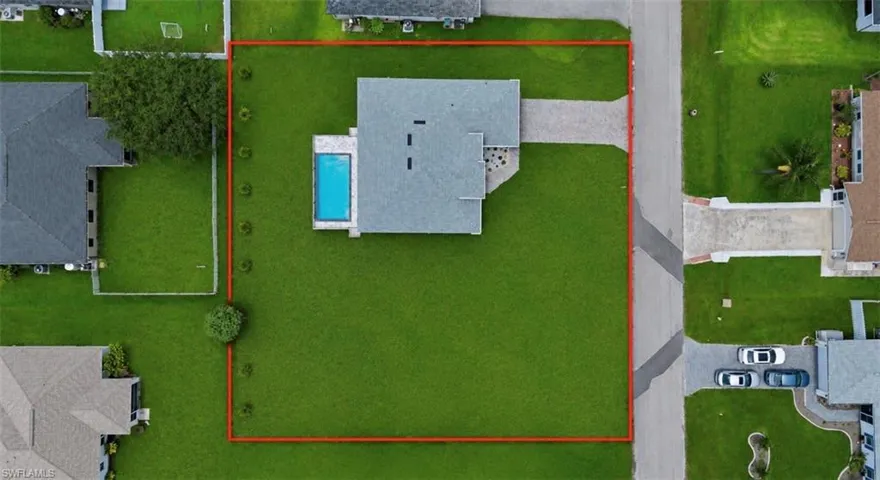 Aerial perspective showcasing a single-story residence with a light gray roof and an integrated swimming pool