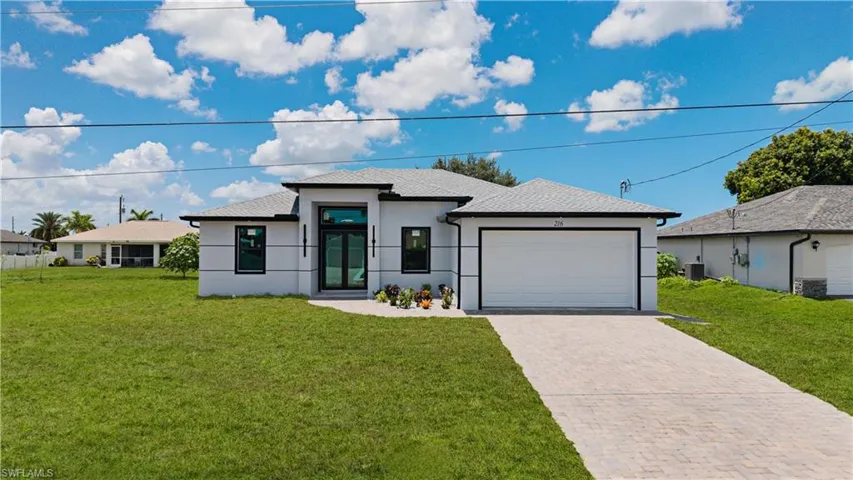 Contemporary single-story residence featuring a light-colored exterior with dark trim accents