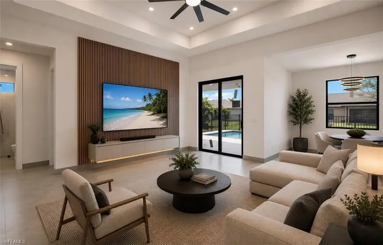 Open concept living area featuring a wood-slat accent wall, recessed lighting, and a modern ceiling fan