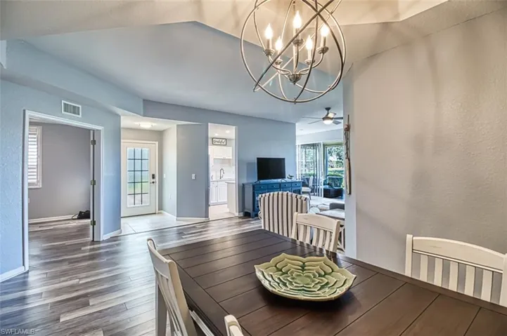 Dining area featuring visible vents, a textured wall, ceiling fan, wood finished floors, and baseboards
