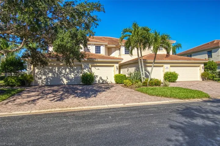 View of front of home featuring a tiled roof, decorative driveway, and stucco siding