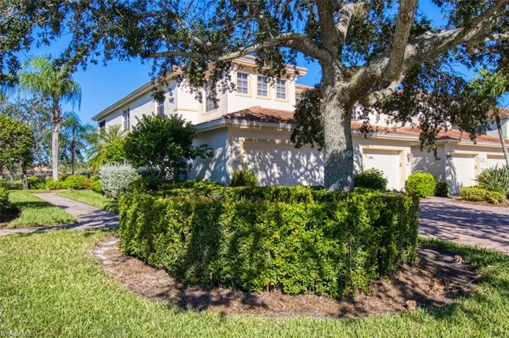 View of front facade featuring a garage, driveway, and stucco siding