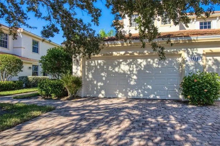 View of front facade with a garage and decorative driveway