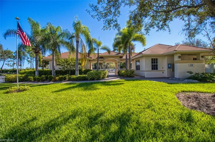 View of front facade featuring a tiled roof, a front lawn, and stucco siding
