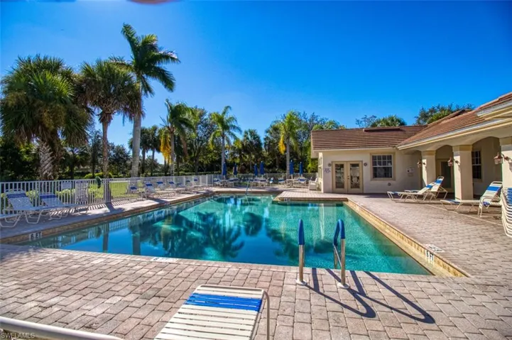 Pool with a patio area and fence
