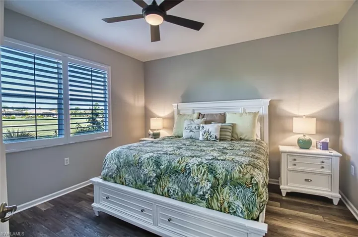 Bedroom featuring dark wood-style flooring, a ceiling fan, and baseboards