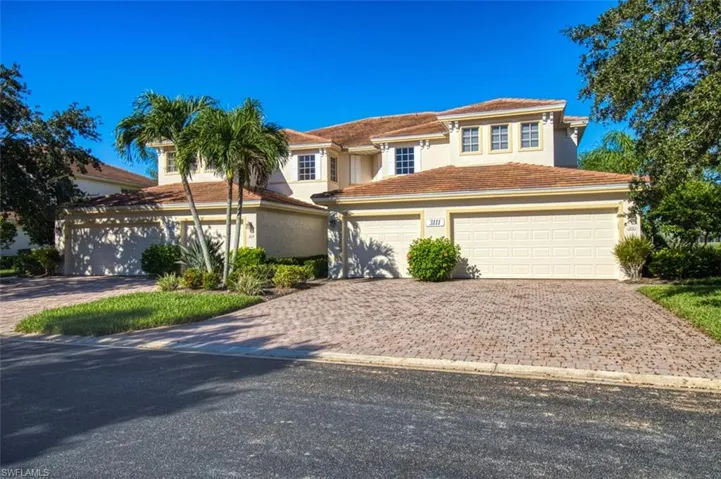 View of front of home with decorative driveway, a tiled roof, an attached garage, and stucco siding