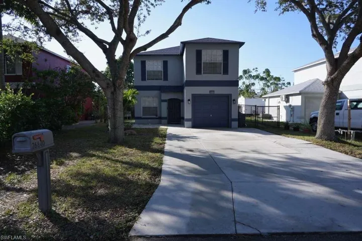 View of front of property with concrete driveway, stucco siding, and a garage