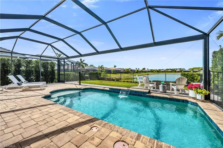 Swimming Pool with Sitting Area. Featuring a Fenced In Backyard with Fire Pit and Lake View.