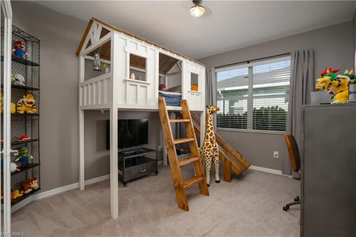 den area being used as a bedroom with light carpet