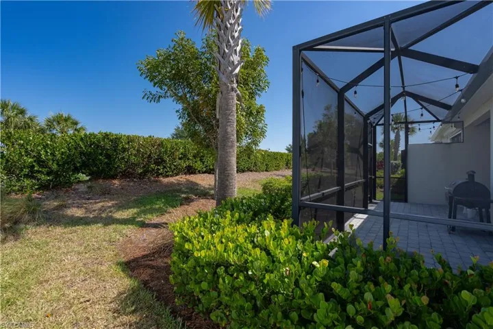 View of yard with glass enclosure and a patio area