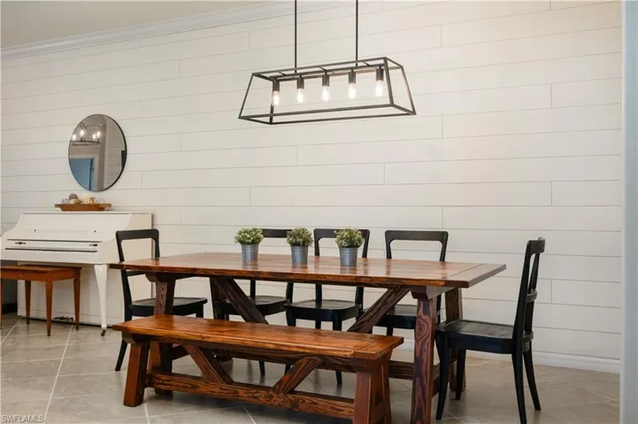 Tiled dining space with crown molding and fully ship lapped back wall spanning the entire length of the gathering space