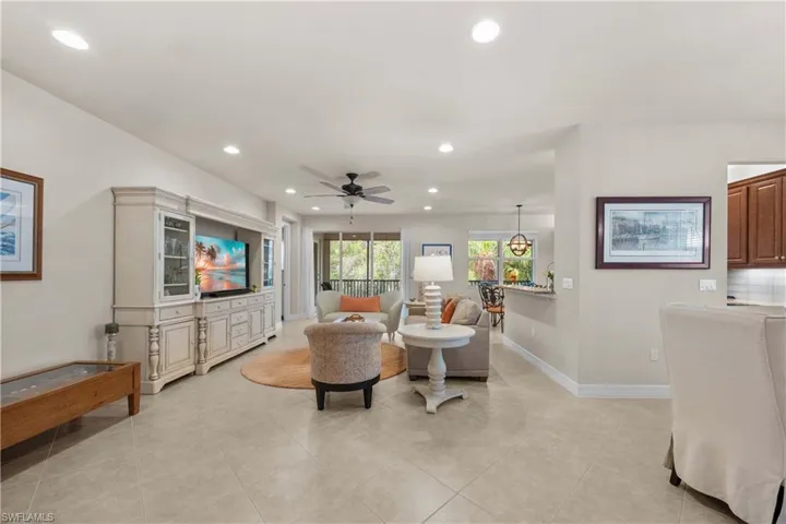 Living room with light tile patterned floors and ceiling fan