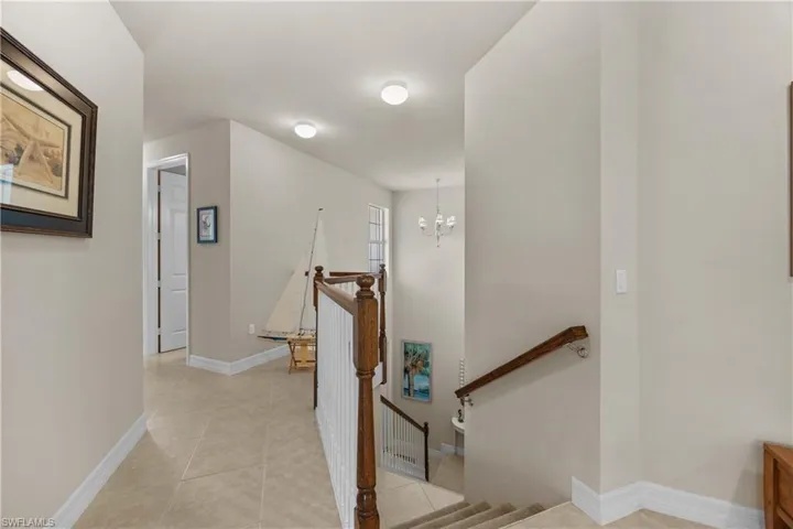 Stairway featuring tile patterned floors and a chandelier