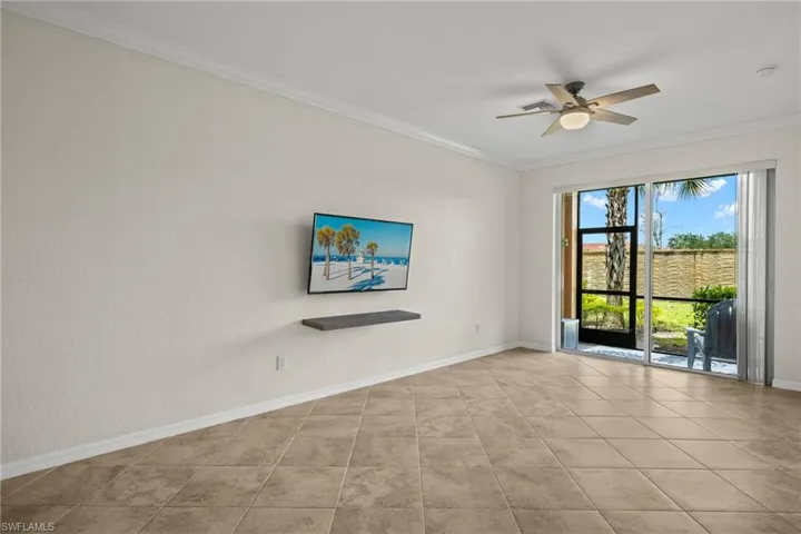 Unfurnished room featuring ceiling fan, light tile patterned floors, and crown molding