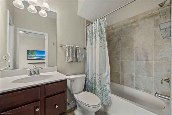Full bathroom featuring shower / bath combo with shower curtain, vanity, and toilet