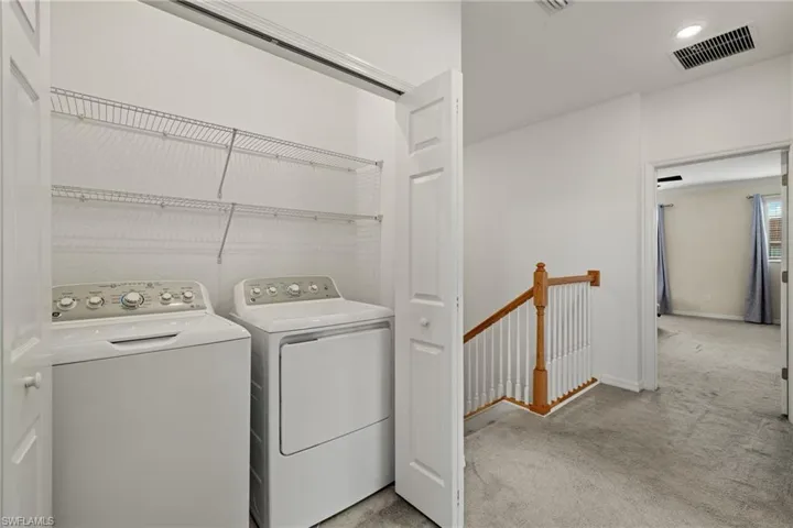 Washroom featuring light carpet and washer and dryer