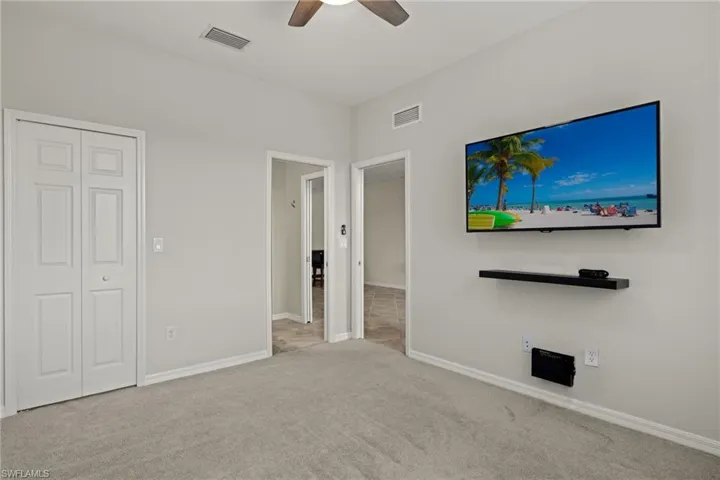 Unfurnished bedroom with a closet, ceiling fan, and light carpet