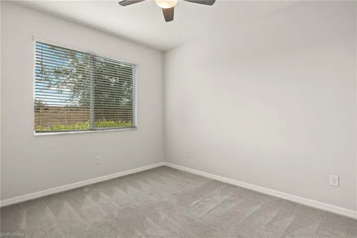Carpeted empty room with ceiling fan
