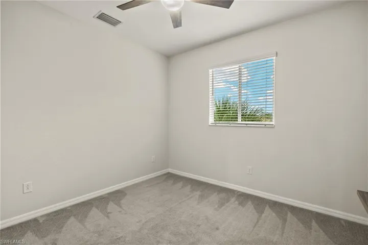 Empty room featuring ceiling fan and carpet floors