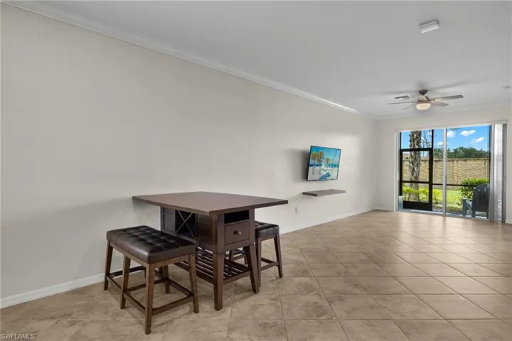 Dining space featuring ceiling fan, light tile patterned flooring, and ornamental molding